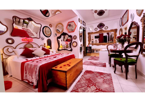 Camera da letto rosa con accenti rossi, specchi e vista sul giardino presso Pupi Catania B&B ad Aci Castello, Sicilia