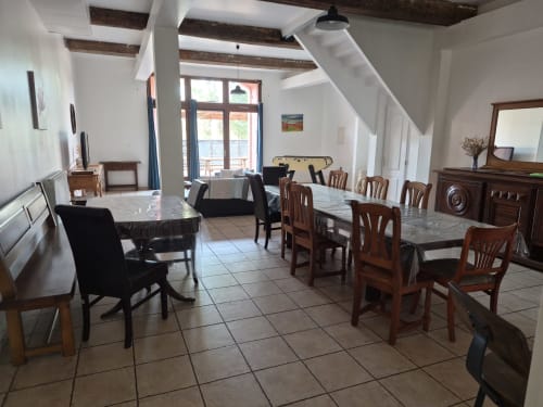 Dining room at Domaine De Poulharies B&B near Carcassonne with wooden beams, tile floors, and mixed seating