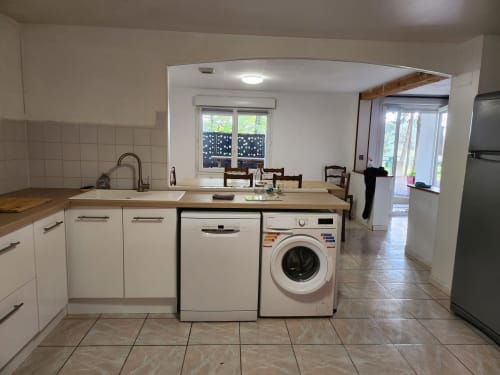 Cuisine moderne avec armoires blanches, lave-vaisselle, lave-linge à Domaine De Poulharies, Carcassonne