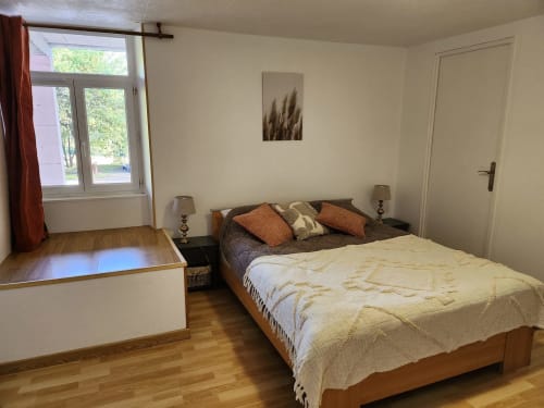 Chambre spacieuse au Domaine De Poulharies B&B à Carcassonne avec parquet, deux lits et lumière naturelle des fenêtres