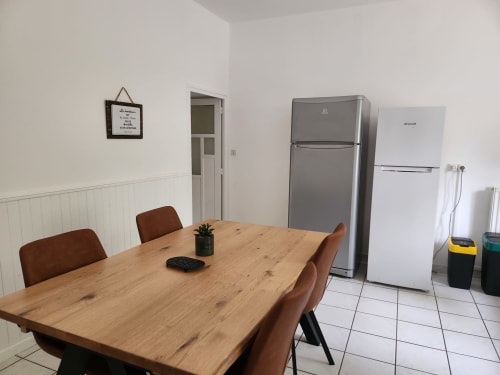 Salle à manger de la Domaine De Poulharies B&B à Carcassonne avec table en bois, chaises marron et acier inoxydable
