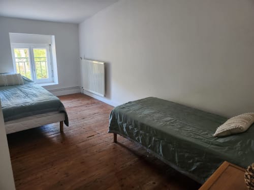 Chambre spacieuse au Domaine De Poulharies près de Carcassonne avec lits jumeaux, parquet et vue sur le jardin