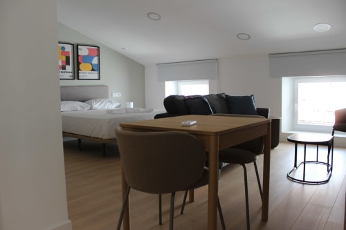 Moderno estudio en Palacio Mambrilla, Valladolid con mesa de comedor, sofá negro y vistas a la ciudad