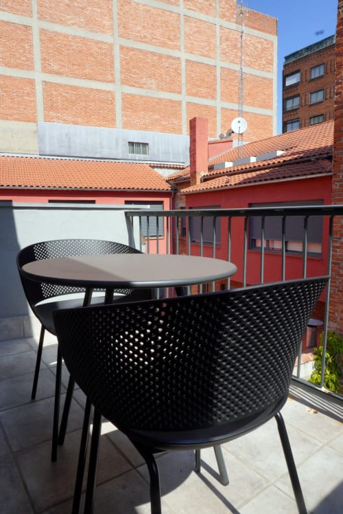 Terraza en la azotea del Palacio Mambrilla Valladolid con sillas modernas negras y mesa redonda con vistas a la ciudad.