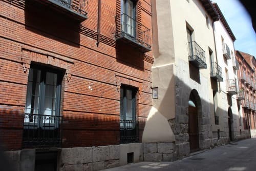 Edificios históricos de ladrillo y piedra en una calle soleada de Valladolid, España, cerca del hotel Palacio Mambrilla