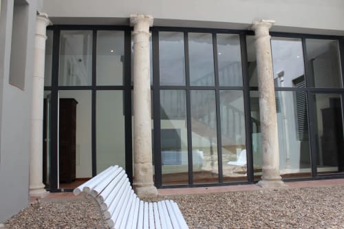 Terraza moderna con banco blanco y puertas de cristal con marco negro en Palacio Mambrilla, apartamento en Valladolid