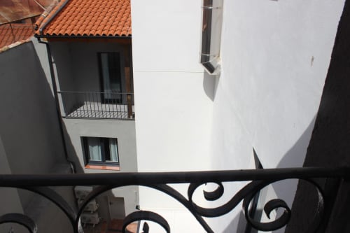 Vista desde balcón del patio de Valladolid en Palacio Mambrilla, edificio de muros blancos con tejado de barro y ornamentación