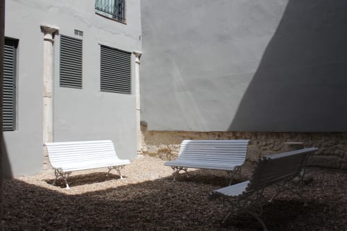 Patio soleado del Palacio Mambrilla en Valladolid con tumbonas blancas y muros de piedra