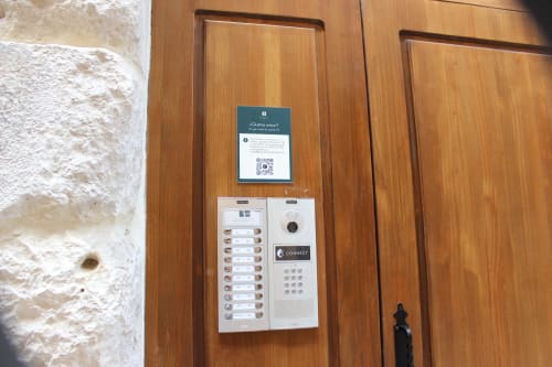 Puerta de entrada de madera del apartamento Palacio Mambrilla Valladolid con portero automático y notificación de error de Windows