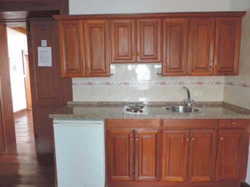 Cocina con muebles de madera, encimera de granito y estufa en el apartamento estudio de Casa Rural Los Helechos, Agulo
