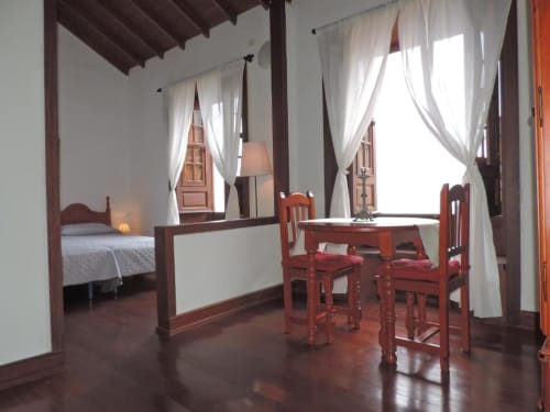 Apartamento estudio en Casa Rural Los Helechos en Agulo con cama dosel, sillas rojas, escritorio y vistas al océano
