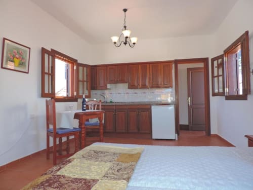 Amplio estudio en Agulo con cocina de madera, zona de dormitorio y suelos de barro en Casa Rural Los Helechos