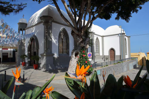 Capilla blanca con ventanas góticas y árbol centenario en la plaza de Agulo, Islas Canarias