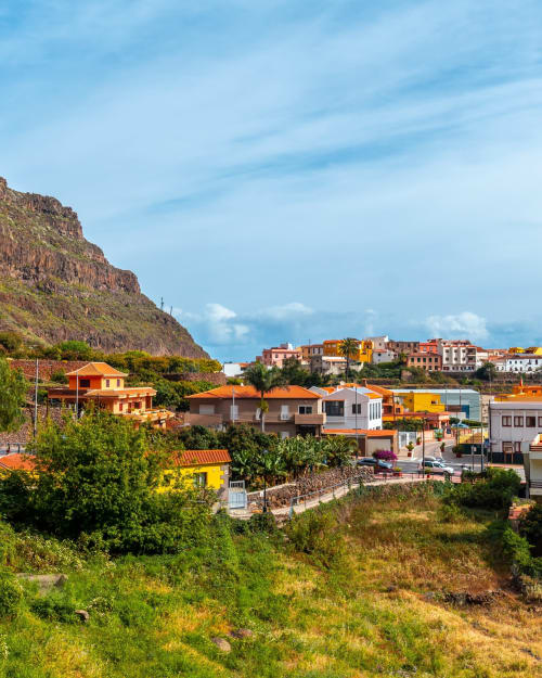 Pintoresco pueblo de Agulo con casas tradicionales acurrucadas en la ladera rocosa bajo cielo azul