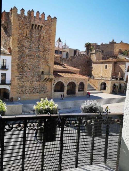 Vista desde el balcón de la Plaza Mayor de Cáceres con torre de castillo histórico y arquitectura medieval desde Apartamentos La Machacona