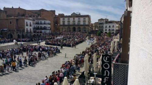 Plaza Mayor de Cáceres con multitudes, vista desde el balcón de Apartamentos La Machacona