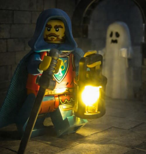 Figurine LEGO sorcier avec lanterne et fantôme dans un donjon de château médiéval au Domaine de Bort