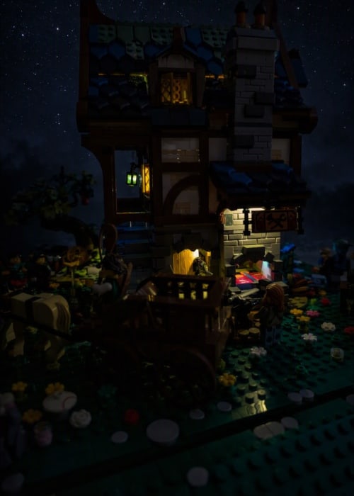 Scène de château LEGO illuminée la nuit avec tours et cour au Domaine de Bort près de Limoges, France
