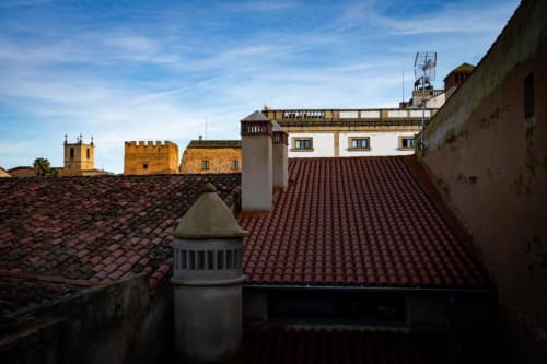 Vista de la terraza de los tejados de Cáceres con tejas rojas y edificios históricos en Apartamentos La Machacona