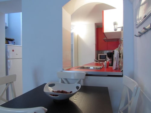 Moderna cocina en Apartamentos La Machacona, Cáceres, con toques rojos y electrodomésticos equipados