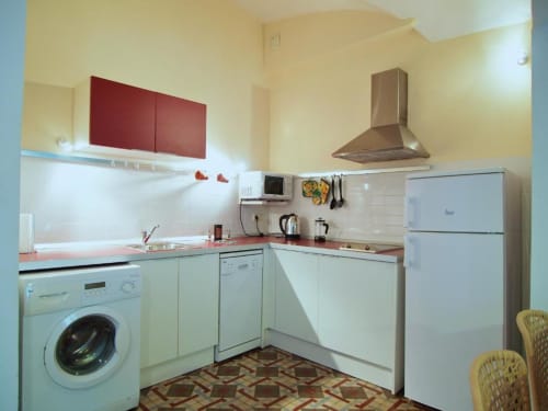 Cocina moderna en apartamento de 1 dormitorio en Apartamentos La Machacona, Cáceres con electrodomésticos blancos y detalles en rojo