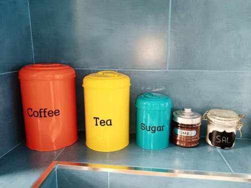 Recipientes de almacenamiento de cocina etiquetados Café, Té y Azúcar en coloridos botes en Apartamentos La Machacona