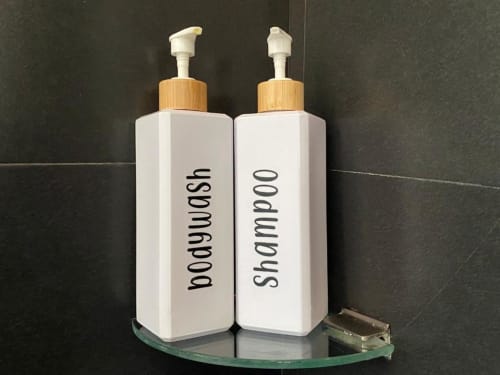 Juego de amenities: botellas de gel de baño y champú con tapones de bambú en Apartamentos La Machacona, Cáceres
