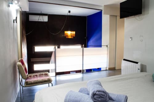 Moderno apartamento de 1 dormitorio en Cáceres con cama, recepción, pared azul y vistas a la ciudad