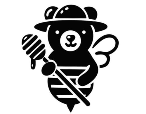 Mascotte ours chef fantasque coiffé d'une toque, tenant ustensile de cuisine et pinceau pour la maison d'hôtes Domaine de Bort près de Limoges