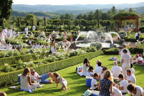 Des familles profitent d'une belle journée ensoleillée dans les jardins paysagés du Domaine De Campagnac, un gîte de charme en