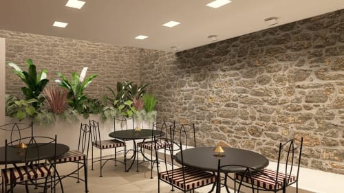 Modern dining area at Feel Sintra with stone walls, black tables, potted plants, and ambient lighting in Sintra, Portugal