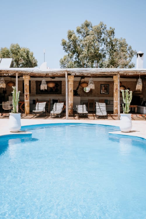 Espace piscine de l'hôtel Eucalyptus à Essaouira avec chaises longues, pergola en bois et eucalyptus