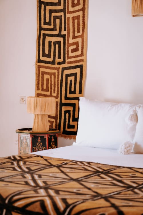 Chambre de l'hôtel Eucalyptus Ethnic à Essaouira avec textiles géométriques et décoration marocaine traditionnelle sur fond blanc