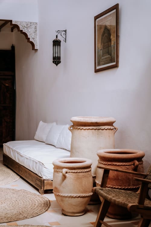 Chambre d'hôtel Eucalyptus à Essaouira avec décor marocain traditionnel, jarres en terre cuite, literie blanche