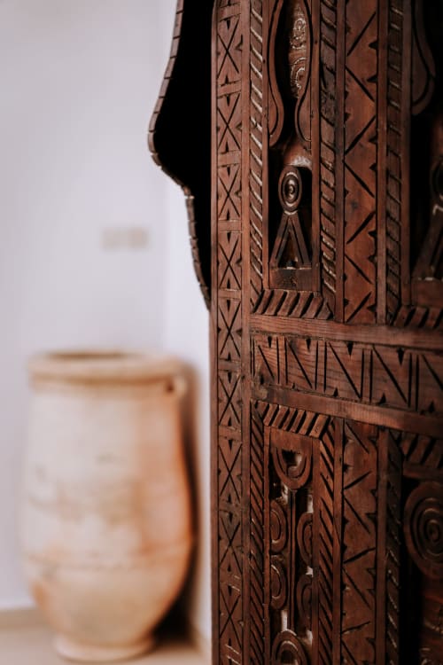 Détail d'une porte en bois sculptée et ornementale de l'hôtel Eucalyptus Ethnic à Essaouira, Maroc, avec motifs géométriques traditionnels et
