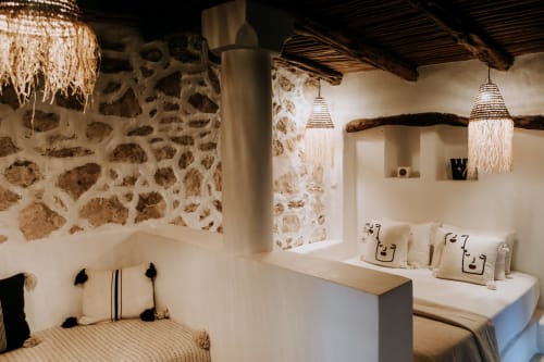 Chambre d'hôtel ethnique Eucalyptus à Essaouira avec murs en pierre, luminaires suspendus tissés et décor marocain traditionnel