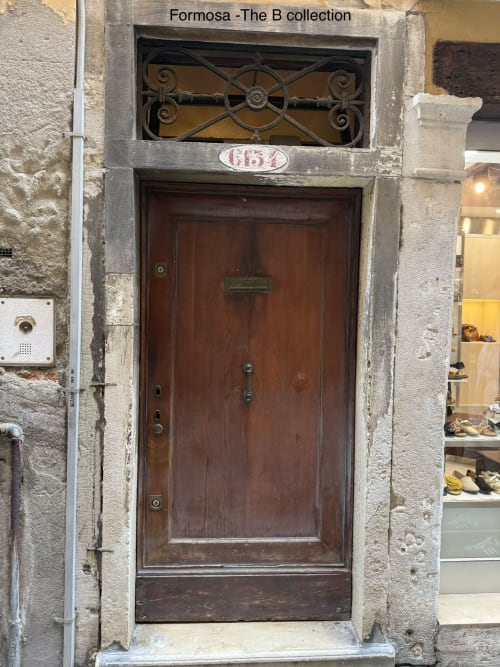 Formosa room entrance at Luxury Loft Venice, wooden door with ornate transom window, Venice Italy