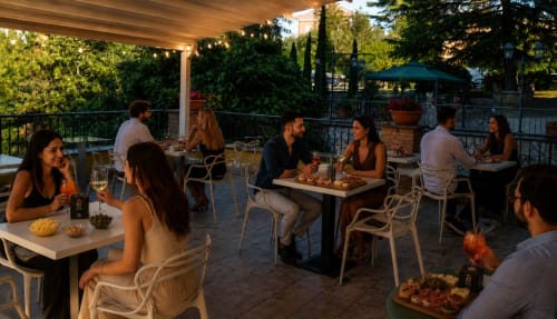 Ospiti che si rilassano durante l'aperitivo serale sulla terrazza del Green Hotel Poggio Regillo a Frascati, Italia
