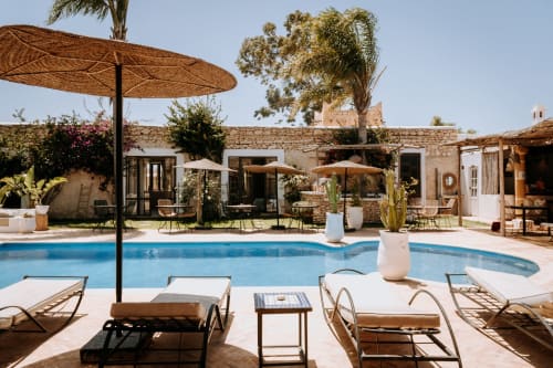 Eucalyptus Ethnic hotel pool area in Essaouira with loungers, umbrellas, and traditional stone architecture