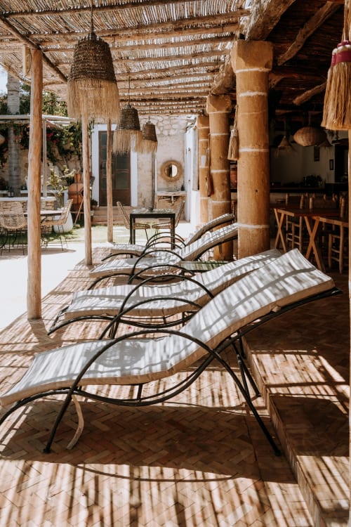 Terrasse ensoleillée avec transats à l'hôtel Eucalyptus Ethnic à Essaouira, Maroc, avec plafond tressé et bois rustique