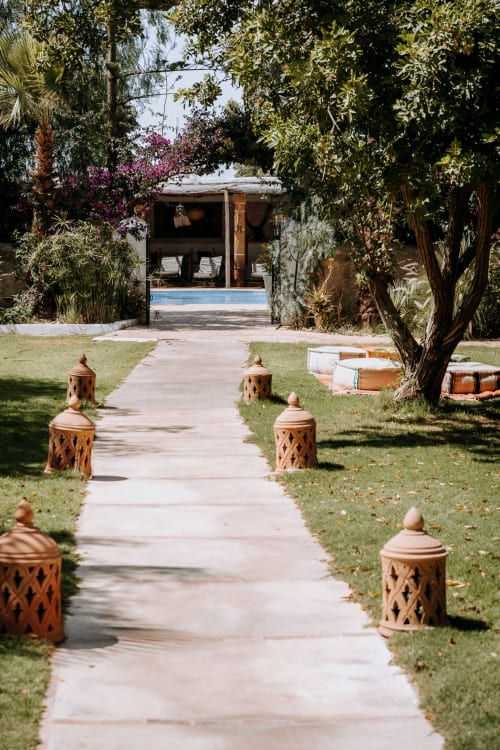 Allée de l'hôtel Eucalyptus avec lanternes en terre cuite, jardin luxuriant et maison de piscine à Essaouira