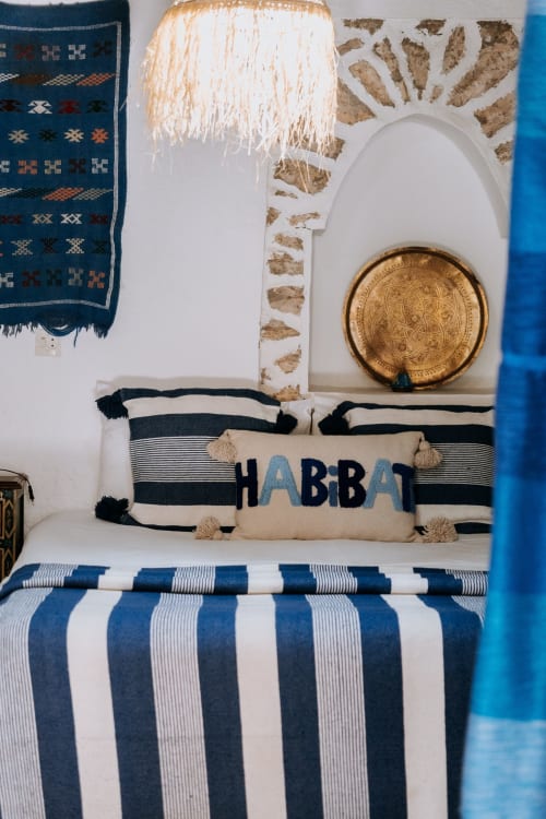 Habitación Bereber acogedora en el hotel Eucalyptus Ethnic con ropa de cama a rayas, almohada HABBA y decoración tradicional en Essaouira.