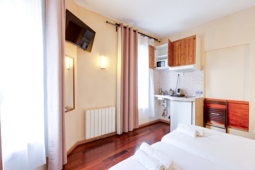 Chambre studio à la Résidence Molière Montrouge avec lit, kitchenette, TV et parquet