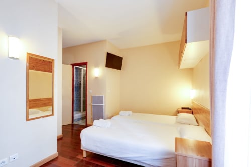 Lits jumeaux Studio Supérieurs avec mobilier en bois, télévision écran plat et éclairage lumineux à l'hôtel Résidence Molière Montrouge