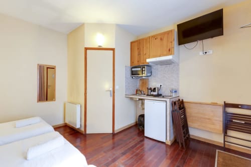 Studio à la Résidence Molière Montrouge avec lit, kitchenette, TV et entrée salle de bain
