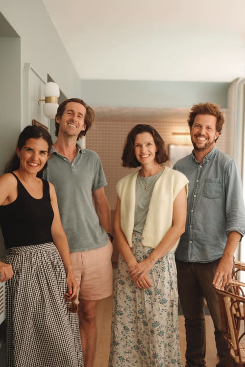 Quatre clients souriants dans un couloir moderne et lumineux de l'Hôtel Saint Enogat à Dinard, France