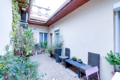 Terrasse commune de la Résidence Molière Montrouge avec sièges, plantes en pots et murs couverts de lierre