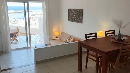 Helles Wohnzimmer mit Meerblick, Esstisch, Sofa und Balkon mit Blick auf den Strand von Morro Jable auf den Kanarischen Inseln