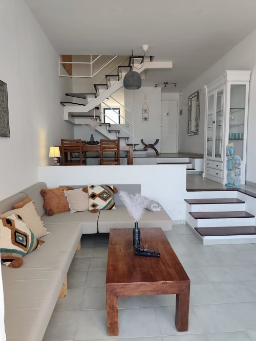 Helles, offenes Wohnzimmer in Fly High mit beigem Sofa, Holztisch und moderner Treppe in Morro Jable