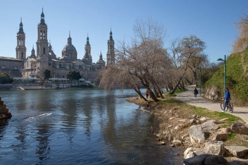 Basílica del Pilar de Zaragoza junto al río Ebro con paseo ribereño y paisaje primaveral